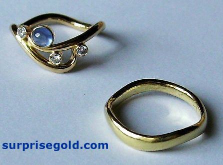 yellow gold wavy wedding ring with aquamarine and diamond engagement ring