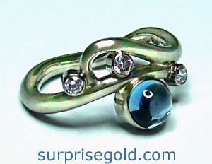 flowing diamond ring design with cabochon aquamarine and three diamonds